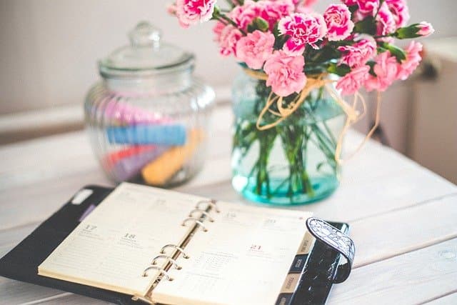 Desk calendar on desk with flowers